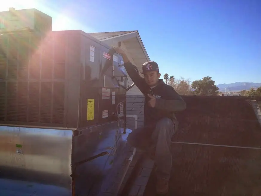 HVAC technician performing HVAC Inspection on a rooftop unit in Oak Island